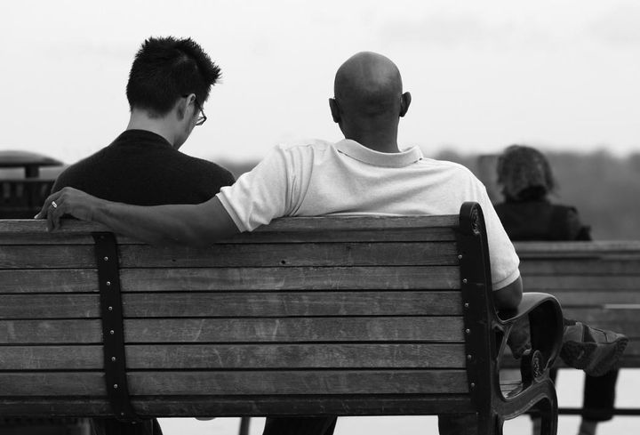 Two men sitting on a park bench together