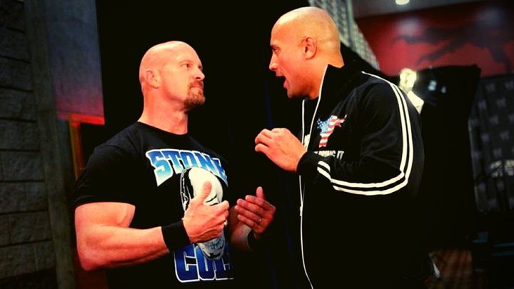 Steve Austin and The Rock having a conversation that looks like an argument (an illustration of forgiveness).