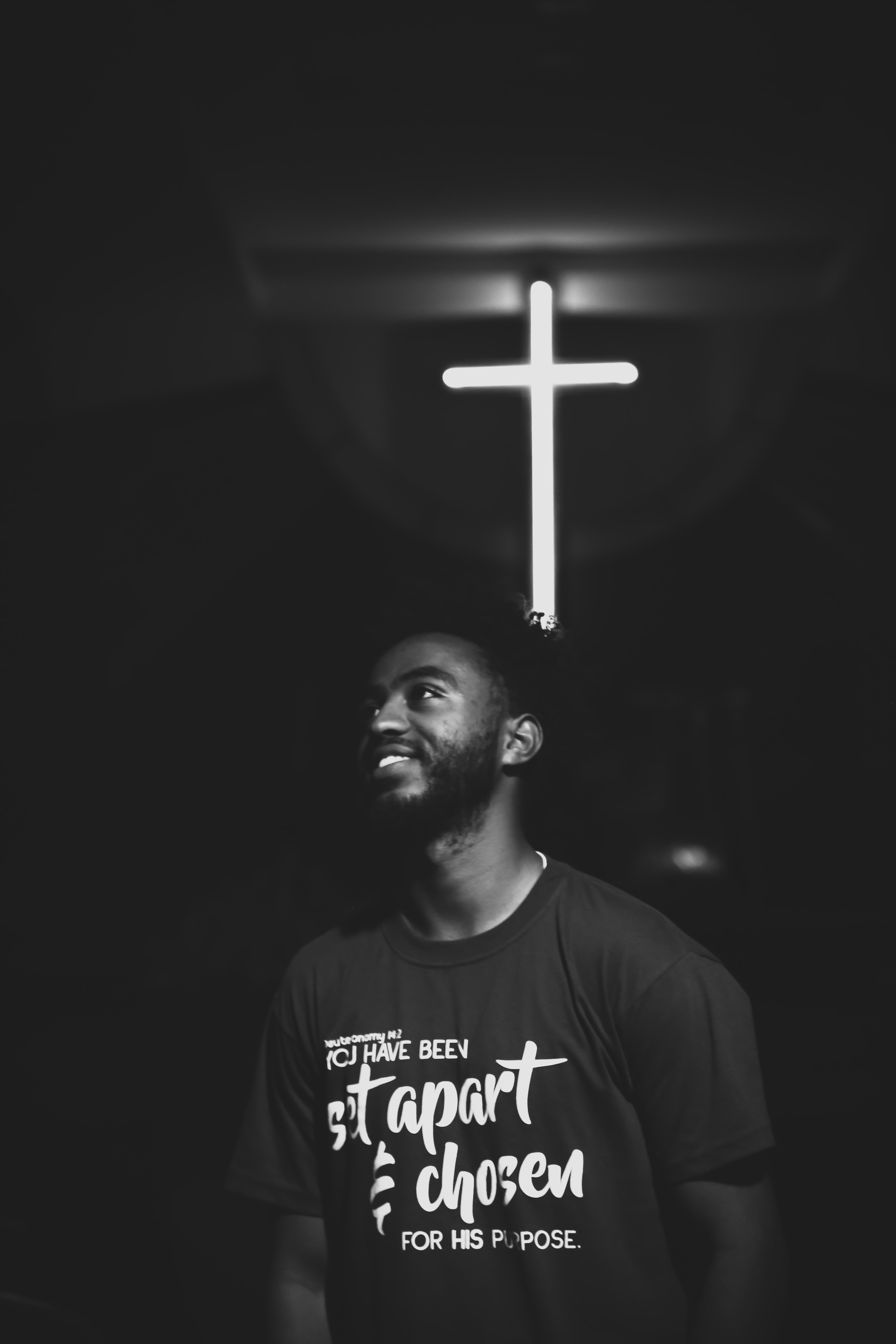 Man smiling in front of a cross